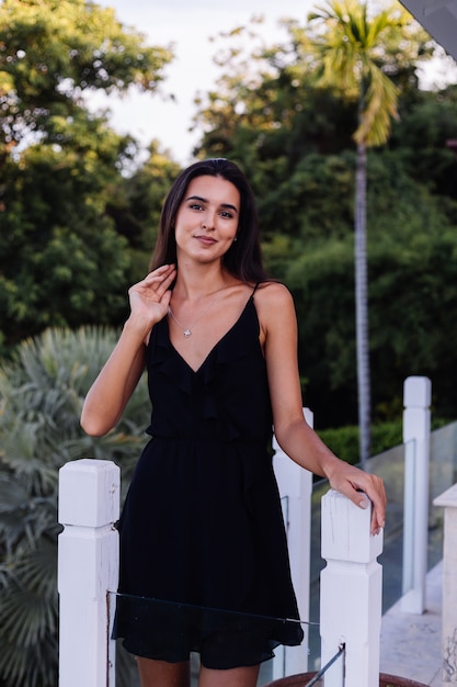 Free photo outdoor portrait of woman in black dress with silver celtic knot necklace