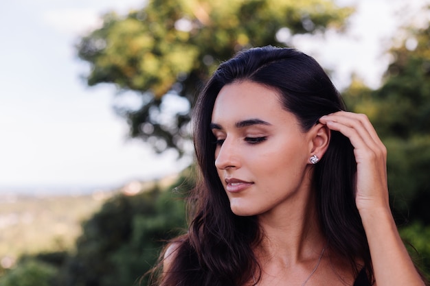 Outdoor portrait of woman with silver celtic knot necklace and earings