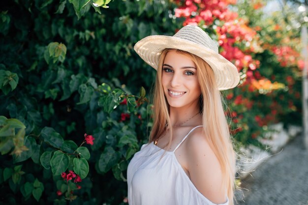 Outdoor portrait of young beautiful happy smiling lady posing near flowering tree. City lifestyle