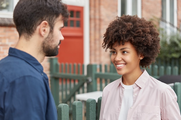 Outdoor shot of cheerful couple having pleasant conversation