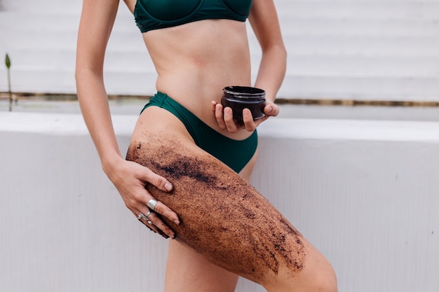 Outdoor shot of woman with coffee body scrub.