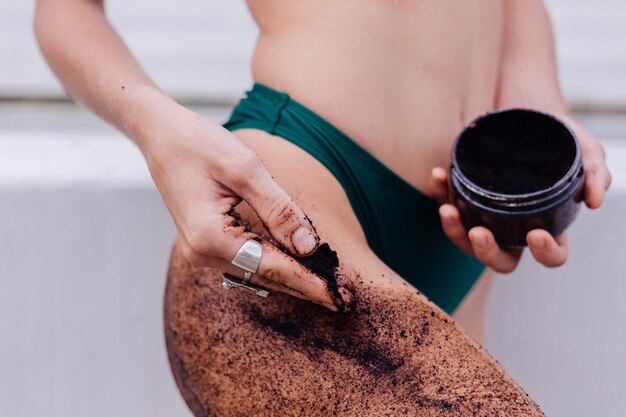 Outdoor shot of woman with coffee body scrub.