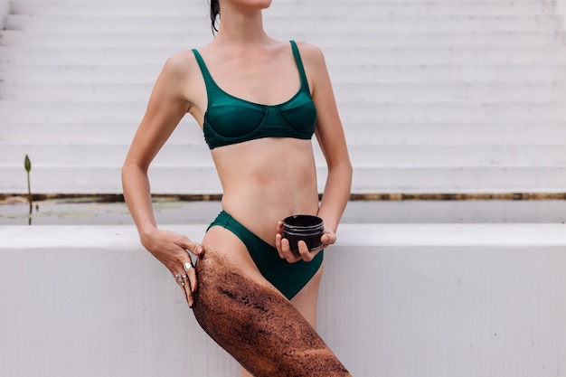 Outdoor shot of woman with coffee body scrub.