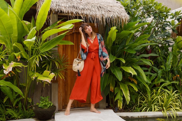 열 대 럭셔리 리조트에서 포즈 boho 복장에 화려한 여자의 야외 여름 패션 사진. 전체 길이. 열대 식물.