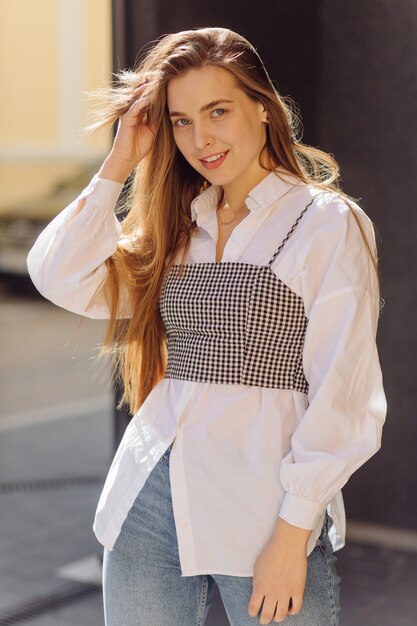 Outdoor summer portrait of young stylish girl posed in sunny day on street