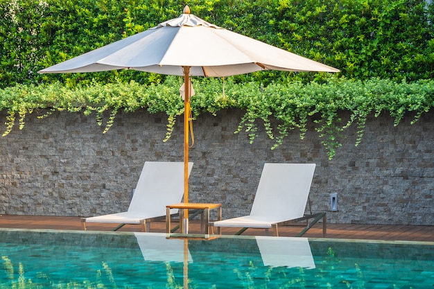 Outdoor swimming pool with umbrella chair lounge around there for leisure travel