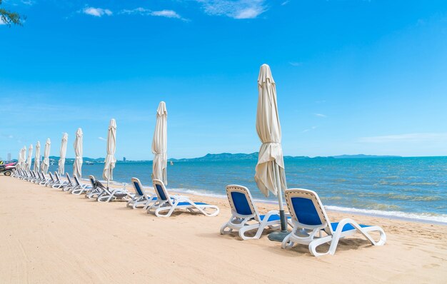 美しい熱帯のビーチと海に傘と椅子が付いた屋外