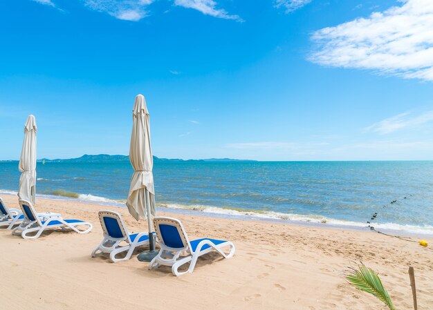 아름다운 열대 해변과 바다에 우산과 의자가있는 야외