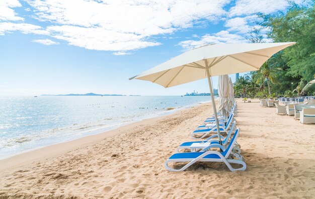 美しい熱帯のビーチと海に傘と椅子が付いた屋外