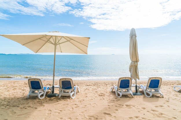 美しい熱帯のビーチと海に傘と椅子が付いた屋外