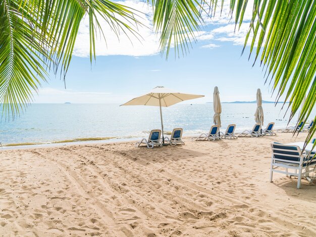 美しい熱帯のビーチと海に傘と椅子が付いた屋外