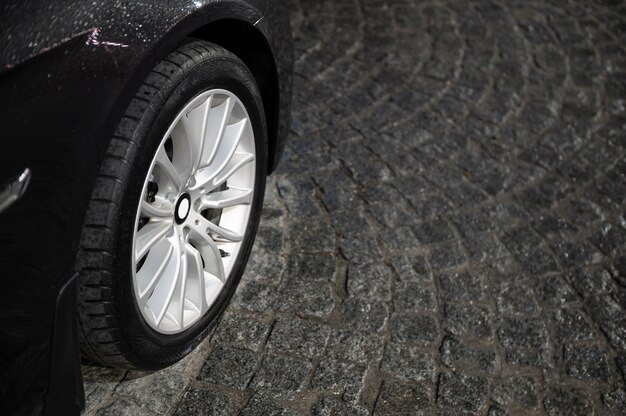 Outdoors cobblestone texture with car wheel