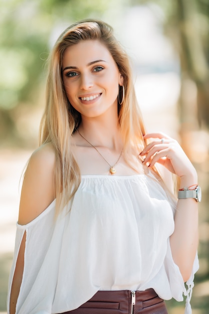 Outdoors portrait of beautiful young brunette girl in park