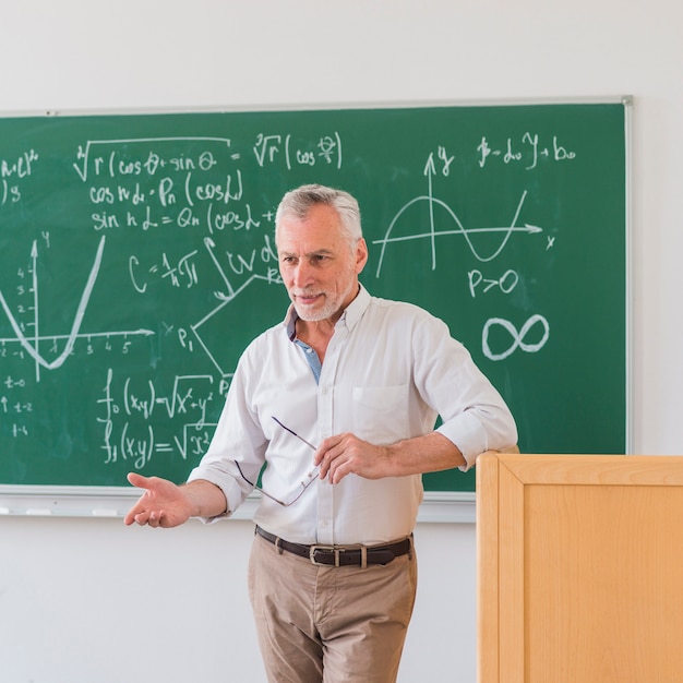 Outgoing lecturer standing at rostrum and explaining material