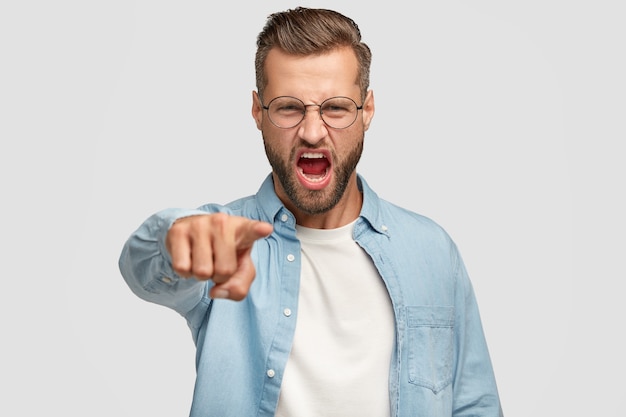 Free photo outraged bearded guy posing against the white wall