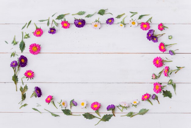 Oval from flowers on wooden tabletop