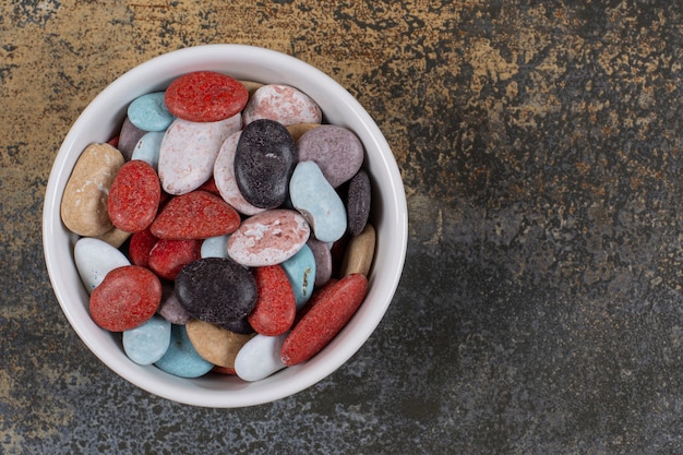 Free photo oval shaped stone candies in white bowl.