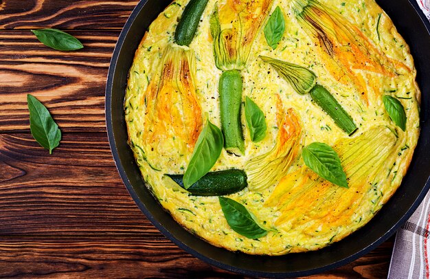 Oven baked omelette with flowers zucchini in pan