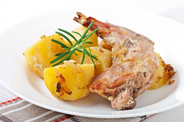 Free photo oven baked rabbit legs with potatoes and rosemary