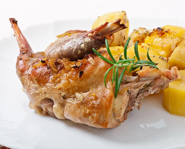 Oven Baked rabbit legs with potatoes and rosemary