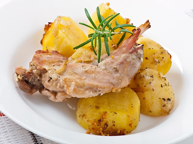 Oven Baked rabbit legs with potatoes and rosemary