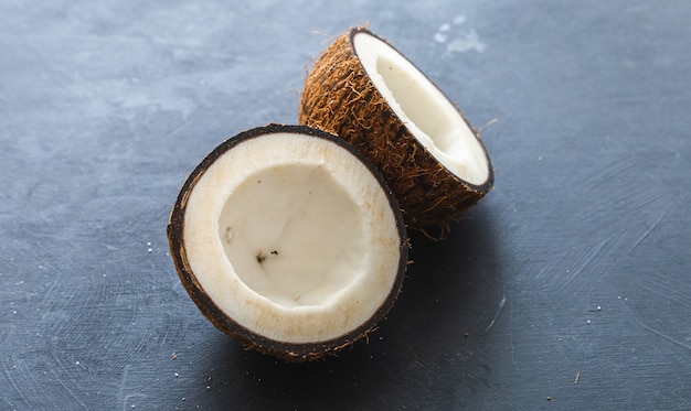 Overhead closeup shot of cut coconuts on a grey table