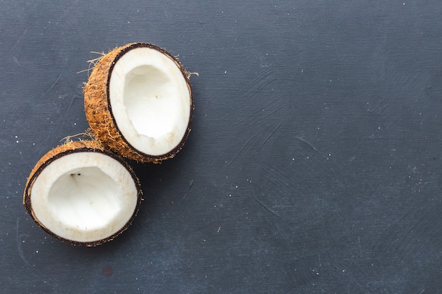 Overhead closeup shot of cut coconuts on a grey table