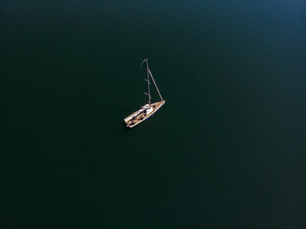晴れた日に美しい湖でのセーリングボートのオーバーヘッドドローン写真
