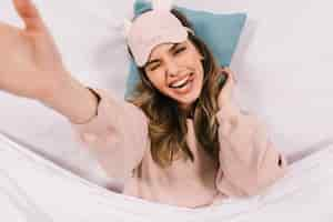 Free photo overhead portrait of young woman lying in bed