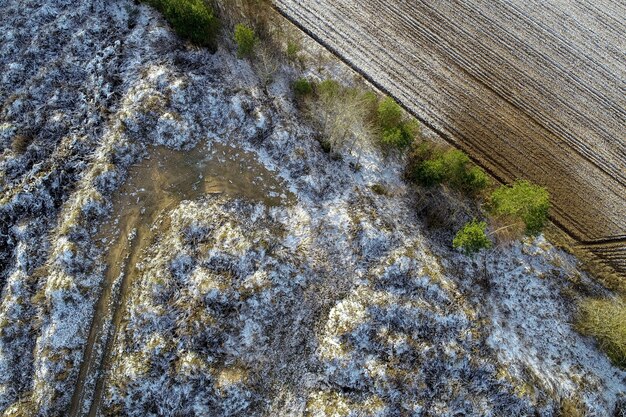 Overhead shot of an agricultural field with drops of snow in the countryside