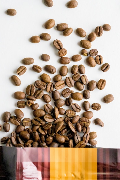 Overhead shot of beans spilled out of the bag on a white surface