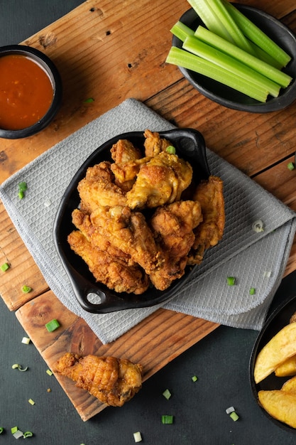 Overhead shot of delicious crispy fried chicken, ketchup and celery sticks on a wooden table