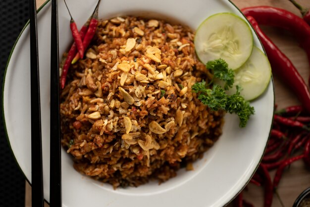 Overhead shot of a dish with rice and sliced vegetable on a round white plate