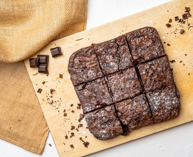 Overhead shot of freshly baked brownies on a wooden board