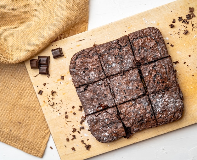 Overhead shot of freshly baked brownies on a wooden board