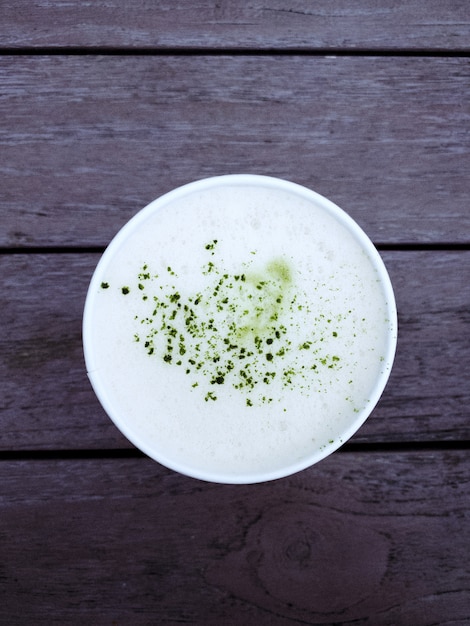 Colpo sopraelevato di un latte del tè verde di matcha su una tavola di legno rustica