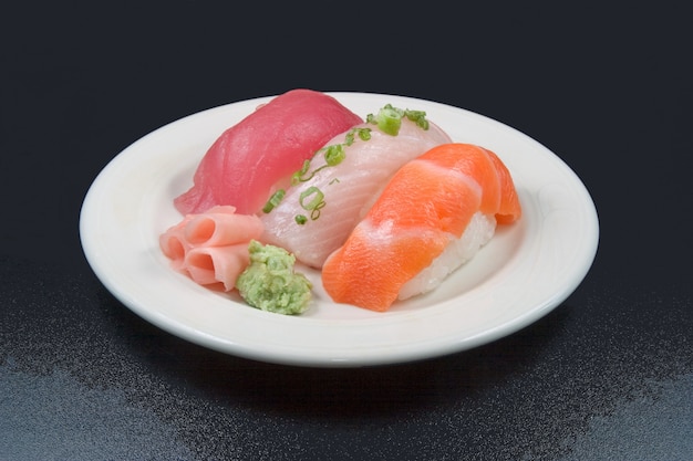 Overhead shot of raw foods placed in a white plate with black color in the background