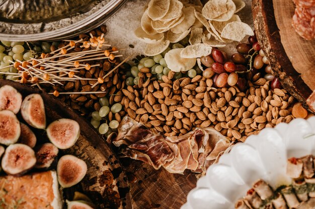 Overhead shot of a table full of almonds, prosciutto, figs, and dry fruit