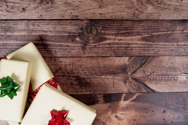 Overhead shot of a wooden surface with a present on the bottom side great for writing holiday text