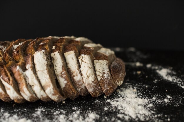 An overhead view of baked bread slices on black backdrop