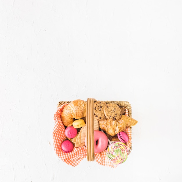 An overhead view of baked and sweet food in the basket over the white background