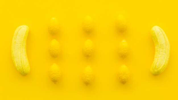 Верхний вид банановых и лимонных конфет на желтом фоне