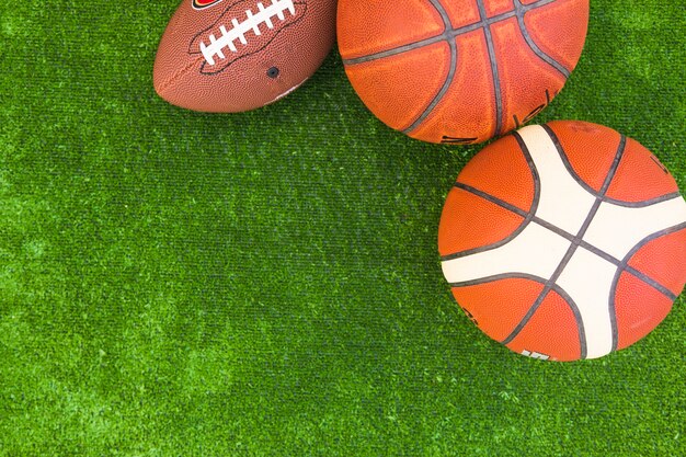 An overhead view of basketball and rugby ball on green turf