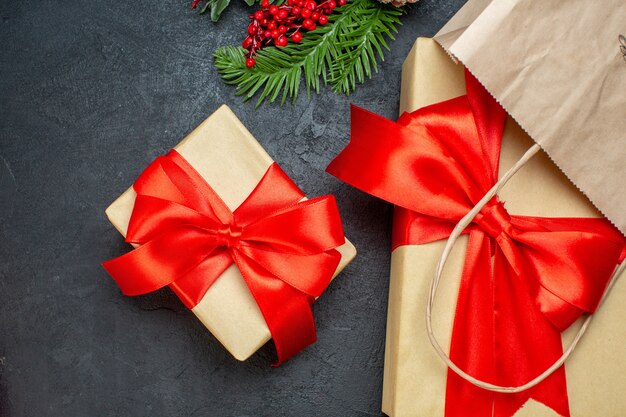 Overhead view of beautiful gifts with red ribbon and fir branches on dark backgrround