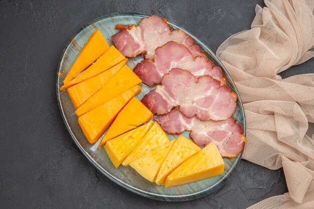 Overhead view of best delicious snacks for wine on a towel on a black background