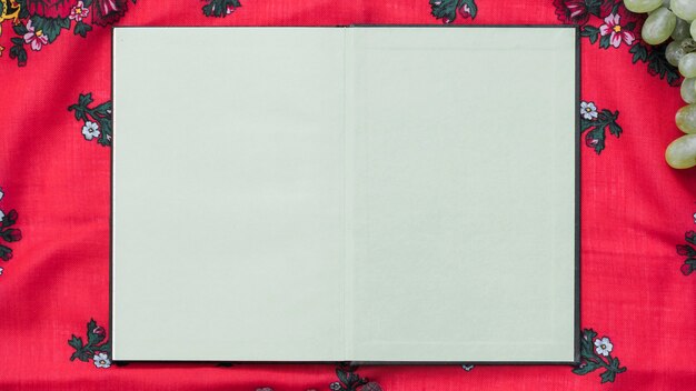 An overhead view of blank notebook on tablecloth