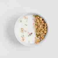 Free photo an overhead view of bowl with oats; milk and pumpkin seeds over white background