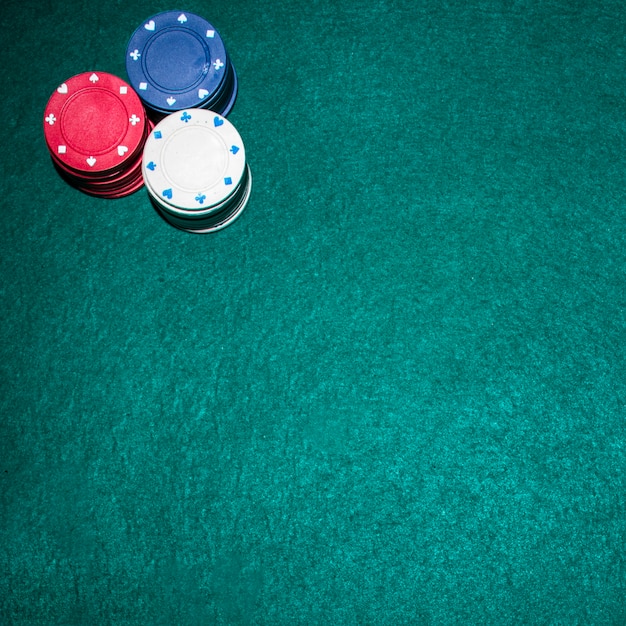 Overhead view of casino chips stack on green poker table