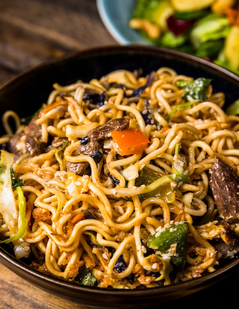 An overhead view of chicken pad thai noodles bowl