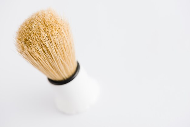 An overhead view of classic shaving brush against white background